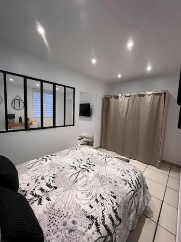 een witte slaapkamer met een bed en een raam bij Maisonnette Cosy in La Ferté-Milon