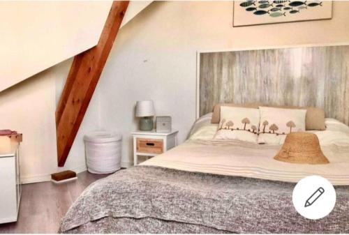 Schlafzimmer mit einem großen Bett mit einem Kopfteil aus Holz in der Unterkunft Balcon sur Sea, Sun and Horses in Deauville