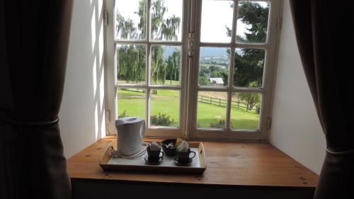 a room with a window and a tea pot on a table at Hotel du Golf de Clécy in Clécy