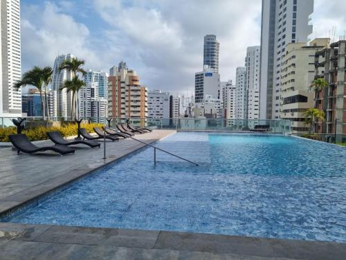 a large swimming pool in a city with buildings at Acogedor y lujoso apartamento en edificio infinitum in Cartagena de Indias