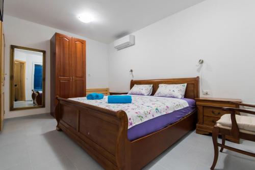 a bedroom with a bed with blue pillows and a mirror at Vila Niko Dalmacija in Sukošan