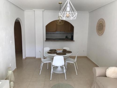 Un comedor con una mesa y sillas blancas. en Residence Angelina, en San Miguel de Salinas