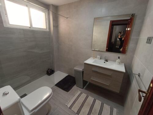 y baño con lavabo, aseo y espejo. en Apartamento luymar, en Torre de Benagalbón