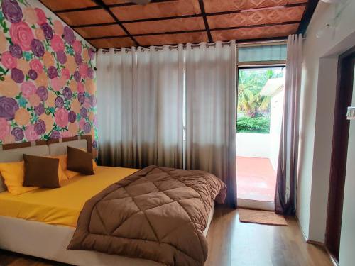 a bedroom with a bed and a large window at The Rustic Manor - Homestay in Bangalore