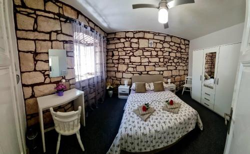 1 dormitorio con cama y pared de piedra en Apartman Marin - Viganj en Viganj
