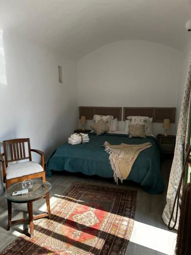 a bedroom with a bed and a chair and a table at Domaine sultana in Awlād ‘Umar