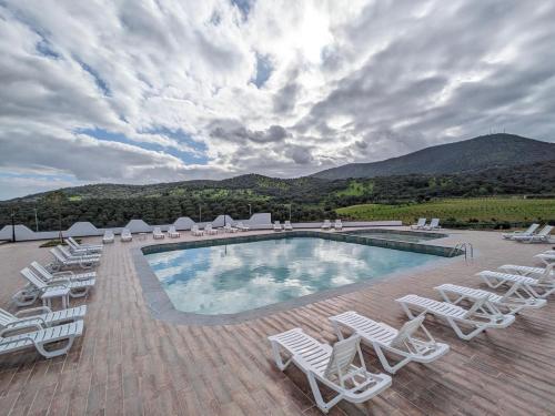 a swimming pool with lounge chairs and a bunch ofitures at L'escale Hôtel & Spa By 7AV HOTELS in Ouazzane