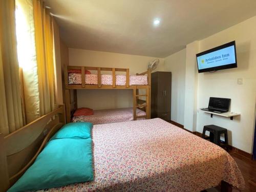 1 dormitorio con 2 literas y TV de pantalla plana en Aristides Inn, en Huarmey
