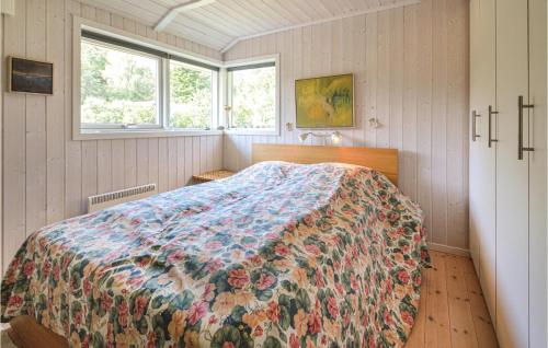 sypialnia z łóżkiem z kwiatowym kocem w obiekcie 3 Bedroom Gorgeous Home In Askeby w mieście Askeby
