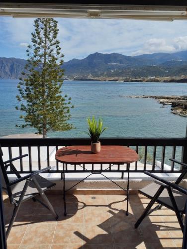 una mesa y sillas en un balcón con vistas al agua en On the sea 2, en Mókhlos