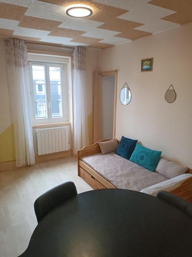 una sala de estar con un sofá y una mesa en le Mont dore Centre ville appartement, en Le Mont-Dore