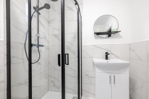 een badkamer met een douche, een wastafel en een spiegel bij Bliss Stay Belfast: The Mount in Belfast