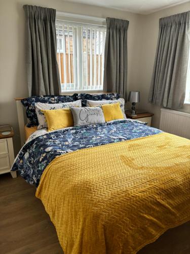 a bedroom with a bed with a yellow comforter at Fabulous Bungalow Norwich in Norwich