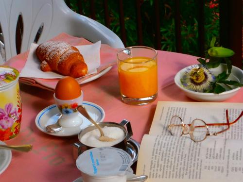 a pink table with a breakfast of eggs and orange juice at Bed and Breakfast da Pio in Castelveccana