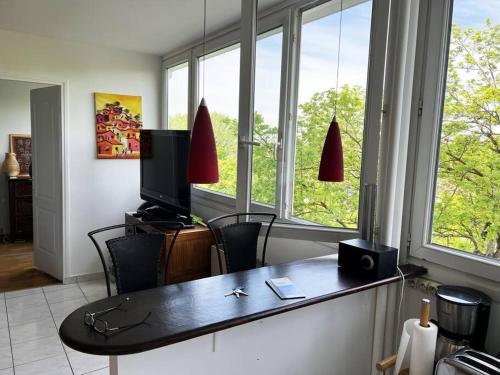 Cette chambre dispose d'un bureau, d'une télévision et de fenêtres. dans l'établissement Appartement lumineux Père Lachaise, à Paris