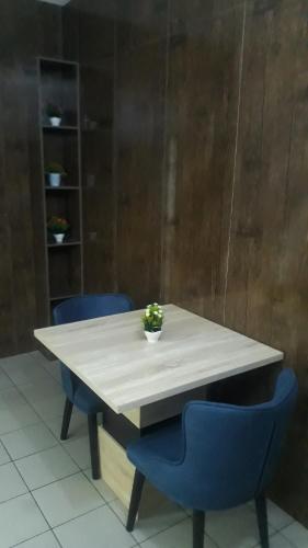 uma mesa branca com duas cadeiras azuis e uma planta sobre ela em OD-V!CK'S LUXE, Wuse Zone 4, Swimming Pool, Gym, WiFi, 24hr power, security, Dstv em Abuja