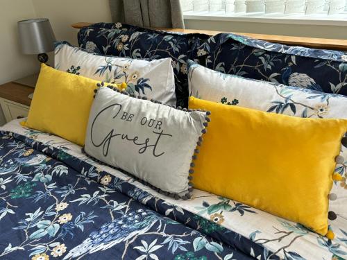 a couch with pillows that say be our guest at Fabulous Bungalow Norwich in Norwich