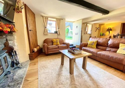 a living room with a leather couch and a table at Luxury Cottage Dog friendly with Hot Tub in Fairford