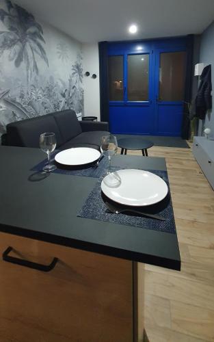 2 assiettes blanches et des verres à vin assis sur un comptoir dans l'établissement Appartement 