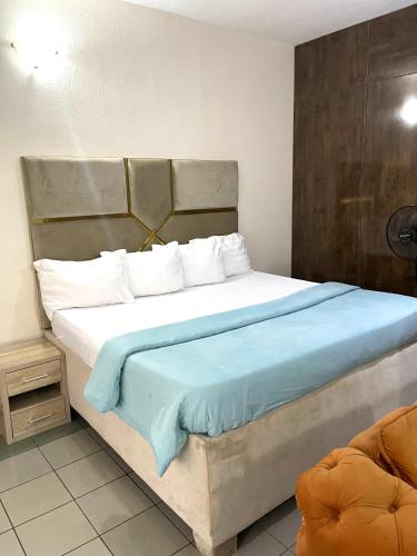 a bedroom with a large bed with blue sheets and pillows at OD-V!CK'S LUXE, WUSE DISTRICT, Swimming Pool, Gym, WiFi, 24hr power, security, Dstv in Abuja