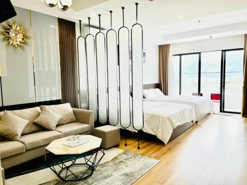 een slaapkamer met een bed en een bank bij Căn Hộ TMS View Biển Quy Nhơn in Quy Nhon