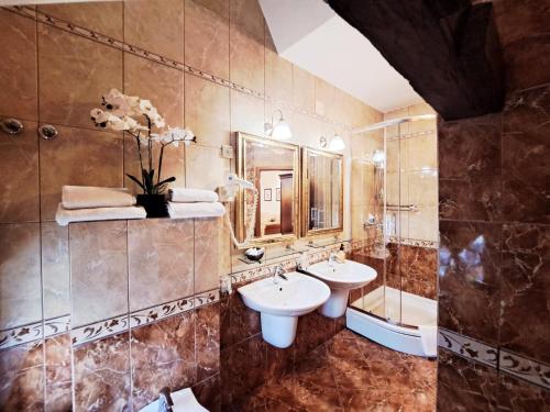 a bathroom with two sinks and a shower and a mirror at Hotel Livadić in Samobor