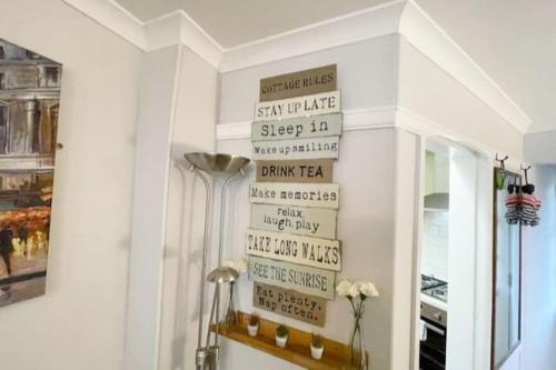 a room with a wall with signs on the wall at A charming cottage set in Bridgetown Totnes. in Dean
