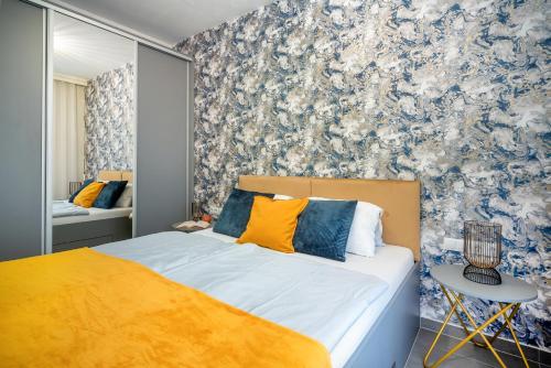 a bedroom with a bed with blue and white wallpaper at LaVida Deluxe villa Hajdúszoboszló in Hajdúszoboszló