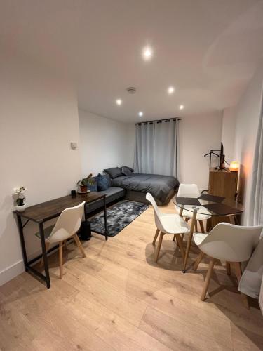 a living room with a couch and a table and chairs at Cosy Maidstone Flat near Station (Town Centre) in Kent