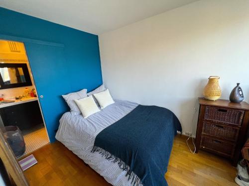 Un dormitorio con una cama con una pared de acento azul en Appartement lumineux Père Lachaise, en París