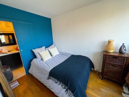 - une chambre dotée d'un lit avec un mur bleu dans l'établissement Appartement lumineux Père Lachaise, à Paris