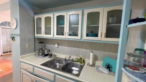 a kitchen with white cabinets and a sink at Caribbean Paradise steps to DayPass Resort&Beach in La Laguna