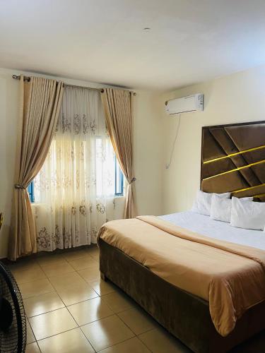 a bedroom with a large bed and a window at OD-V!CK'S LUXE, WUSE DISTRICT, Swimming Pool, Gym, WiFi, 24hr power, security, Dstv in Abuja