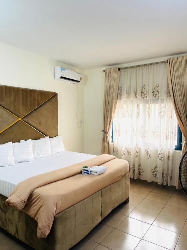 a bedroom with a large bed and a window at OD-V!CK'S LUXE, WUSE DISTRICT, Swimming Pool, Gym, WiFi, 24hr power, security, Dstv in Abuja