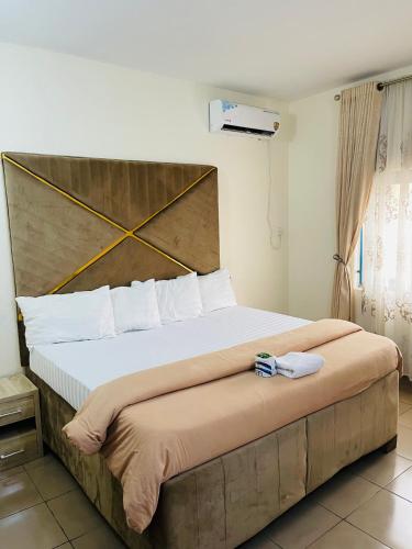 a bedroom with a large bed with a large headboard at OD-V!CK'S LUXE, WUSE DISTRICT, Swimming Pool, Gym, WiFi, 24hr power, security, Dstv in Abuja