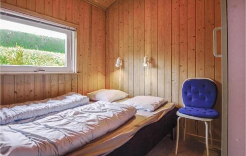 HejlsにあるNice Home In Hejls With 3 Bedrooms, Sauna And Wifiのベッドと青い椅子が備わる客室です。