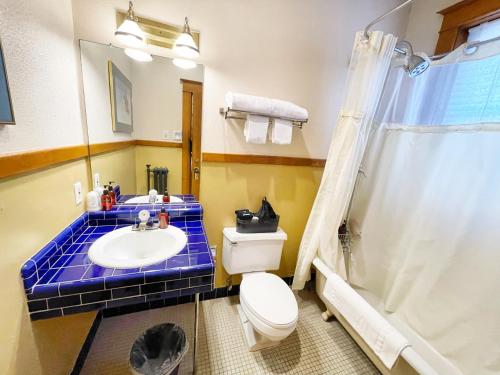 a bathroom with a toilet and a sink and a shower at Hotel Vendome in Prescott