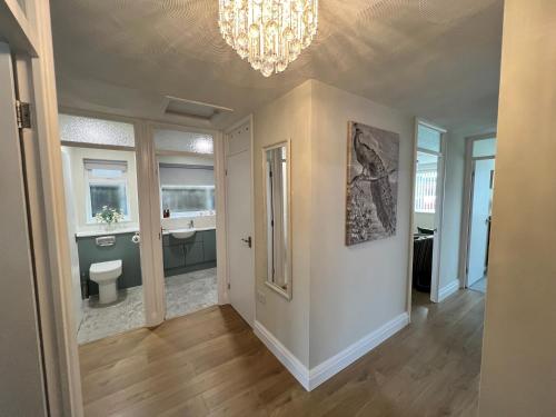 a room with a bathroom with a toilet and a chandelier at Fabulous Bungalow Norwich in Norwich