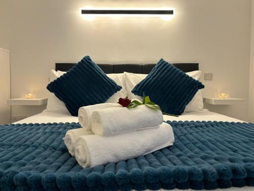 1 cama grande con toallas y almohadas azules en Coastal Escape, en Burtonport