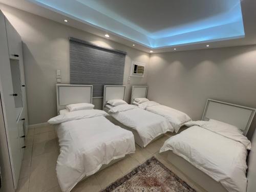 a group of four beds in a room at شقة مخدومه مفروشة قباء 303 in Al Madinah