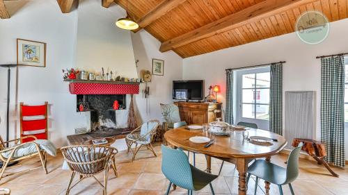 un salon avec une table et des chaises et une cheminée dans l'établissement Maison vendeenne, à La Barre-de-Monts