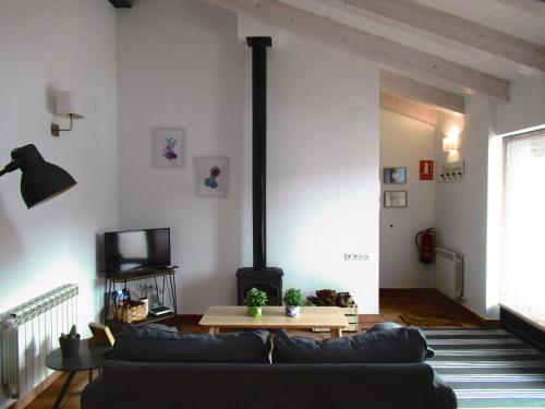 sala de estar con sofá y chimenea en El Huertecito, en Navarredonda de Gredos