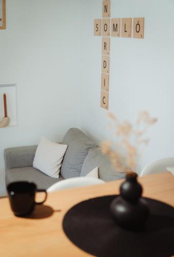 a living room with a couch and a table with a clock at Somló Nordic in Somlószőlős