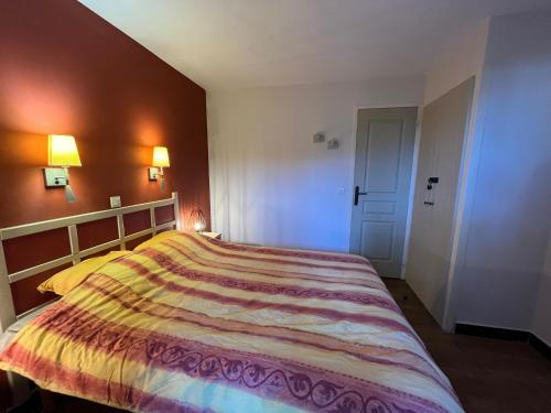 une chambre avec un grand lit avec une couverture colorée dans l'établissement Appartement à Cannes résidence villa francia, à Cannes