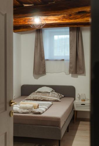 a bed in a room with a window at Somló Nordic in Somlószőlős
