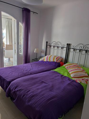 a bedroom with two beds with purple sheets at Villa stamalmar in Villaricos