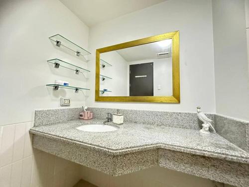 um banheiro com uma pia e um espelho em 3BR Resort Style Condo em Manilla