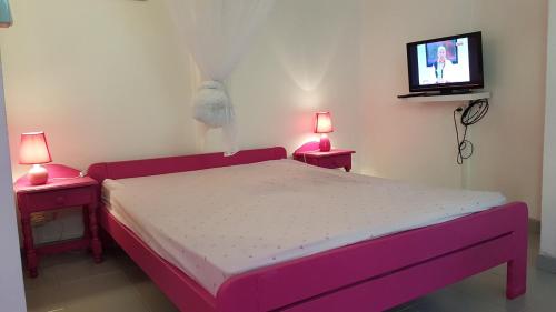 - une chambre avec un lit et une télévision murale dans l'établissement villa marie eugenie, à Les Trois-Îlets