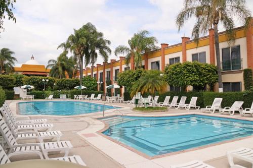 een zwembad met ligstoelen en een resort bij Holiday Inn La Piedad, an IHG Hotel in La Piedad Cavadas