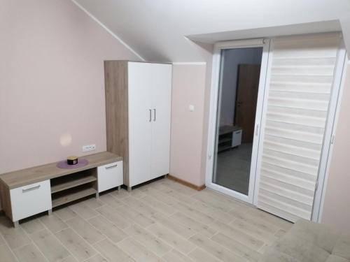 a white room with a desk and a mirror at Apartman Dalmacija in Ečka